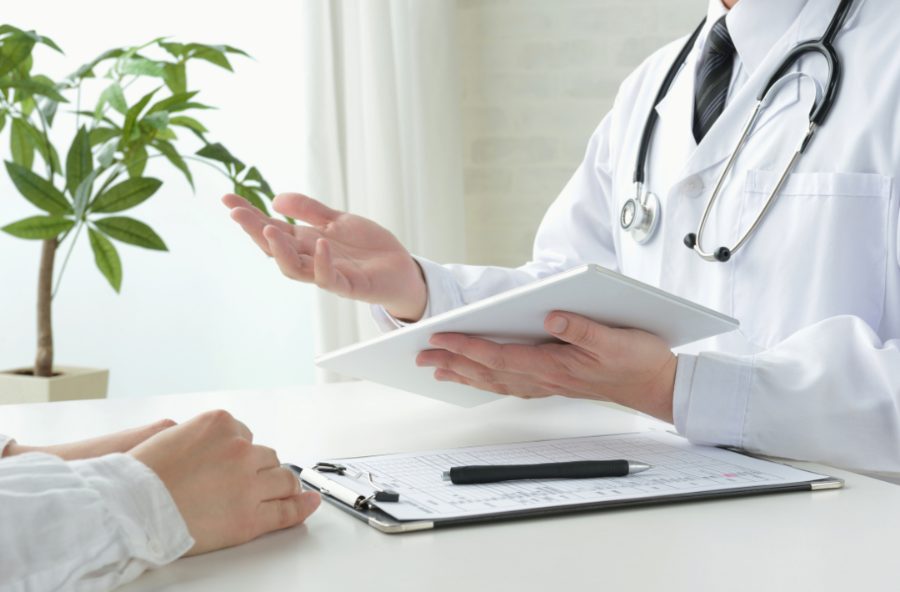 Médico em consulta apresentando orientações a um paciente