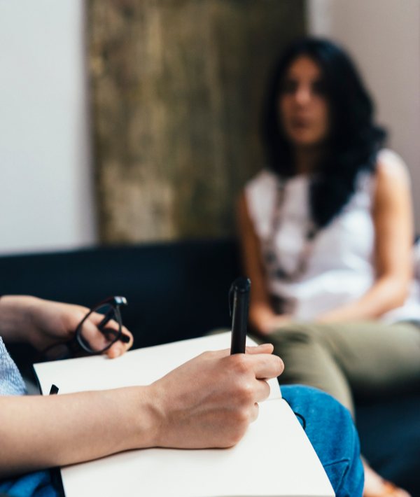 Sessão de psicologia com profissional fazendo anotações